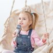 A small cheerful child learns to sing songs. The concept of childhood, performer, life style, music.