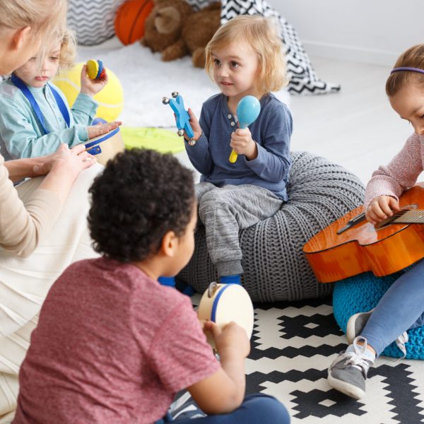 Playing the music Group of little children playing music in kindergarten